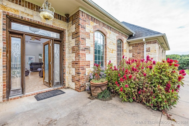 entrance to property featuring brick siding and roof with shingles