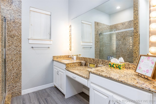 bathroom with vanity, wood finished floors, baseboards, recessed lighting, and a shower stall