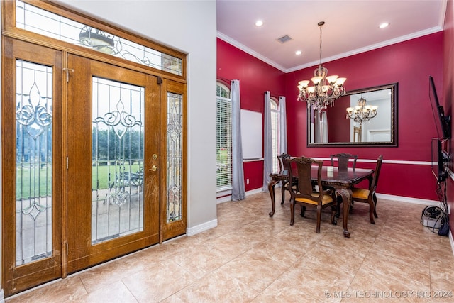 tiled entrance foyer featuring baseboards, visible vents, ornamental molding, and an inviting chandelier