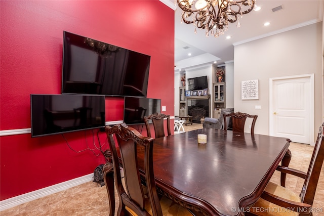 dining room with built in shelves, ornamental molding, and a chandelier