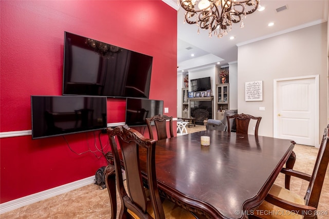 dining area with crown molding, visible vents, a fireplace, and an inviting chandelier