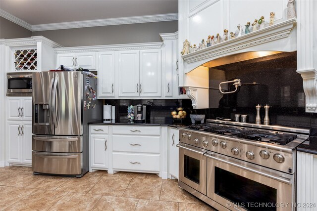 kitchen with appliances with stainless steel finishes, decorative backsplash, ornamental molding, and white cabinets