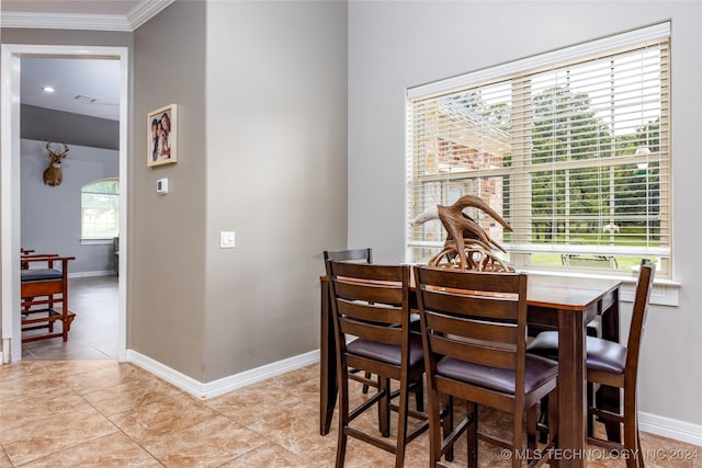 dining space featuring baseboards, ornamental molding, and light tile patterned floors