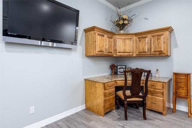 office featuring built in study area, ornamental molding, light wood-style floors, and baseboards