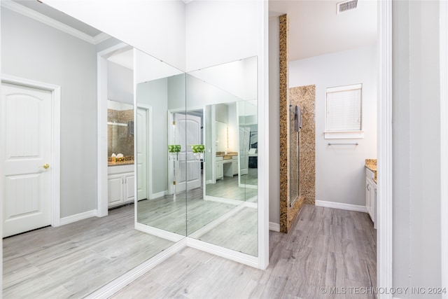 bathroom with ornamental molding, vanity, hardwood / wood-style flooring, and a shower with shower door