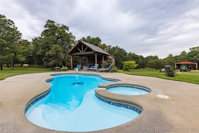 pool with an in ground hot tub, a patio, a gazebo, and a yard