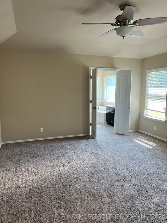 carpeted spare room with a wealth of natural light and ceiling fan