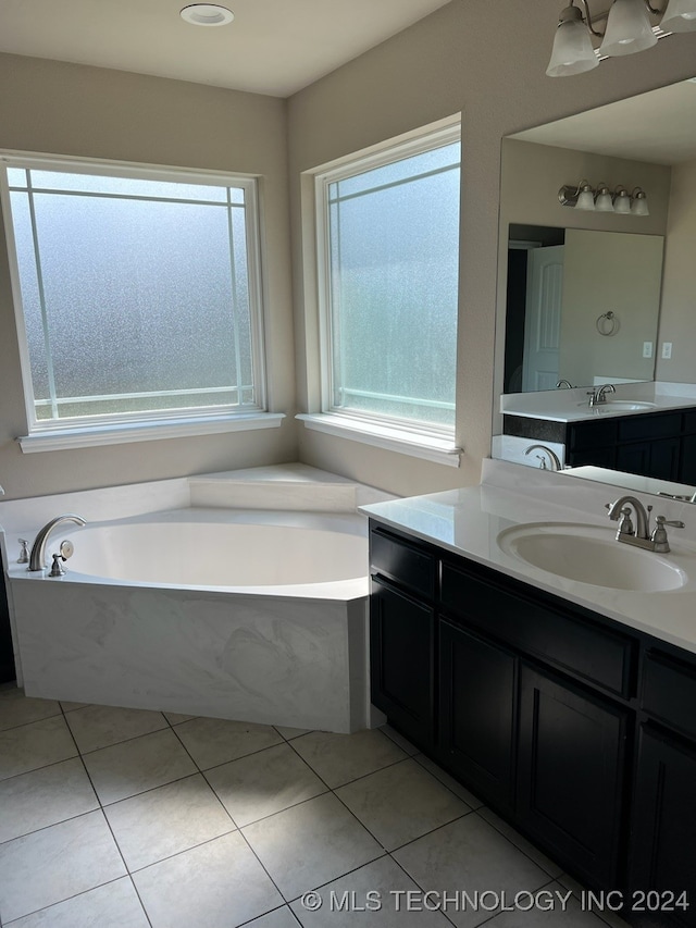 bathroom featuring vanity, a wealth of natural light, tile patterned floors, and a washtub