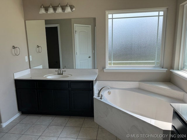 bathroom with tile patterned flooring, vanity, a healthy amount of sunlight, and a bathtub