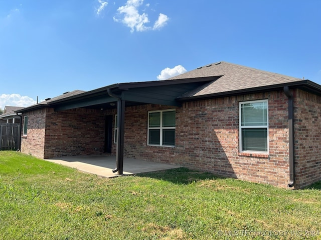 back of property featuring a lawn and a patio