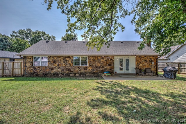 rear view of property with a lawn, a patio, and french doors