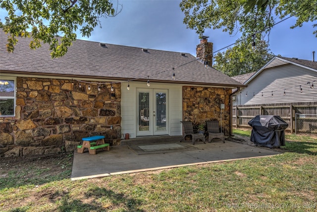 back of house featuring french doors, a lawn, and a patio