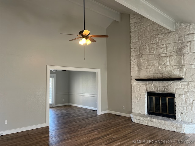 unfurnished living room featuring ceiling fan, a fireplace, dark hardwood / wood-style flooring, and vaulted ceiling with beams