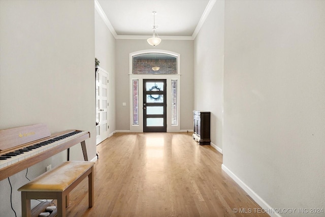 foyer with light wood-type flooring and ornamental molding