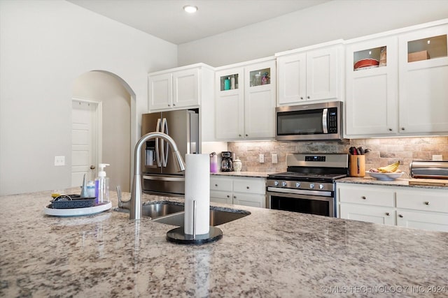 kitchen featuring light stone counters, white cabinets, and appliances with stainless steel finishes