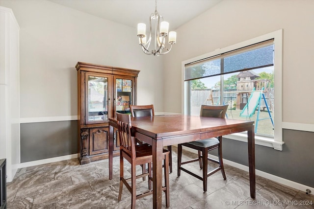 dining room featuring a notable chandelier, plenty of natural light, and vaulted ceiling