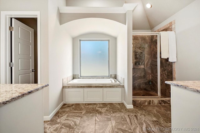 bathroom featuring vanity, separate shower and tub, and vaulted ceiling