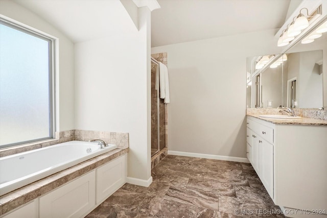 bathroom with plus walk in shower, vanity, and a healthy amount of sunlight