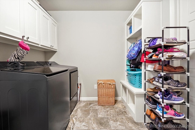 clothes washing area with cabinets and washer and clothes dryer