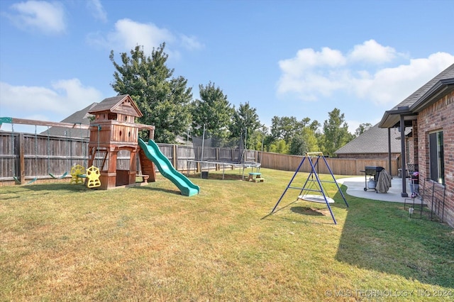 view of jungle gym with a lawn, a patio area, and a trampoline