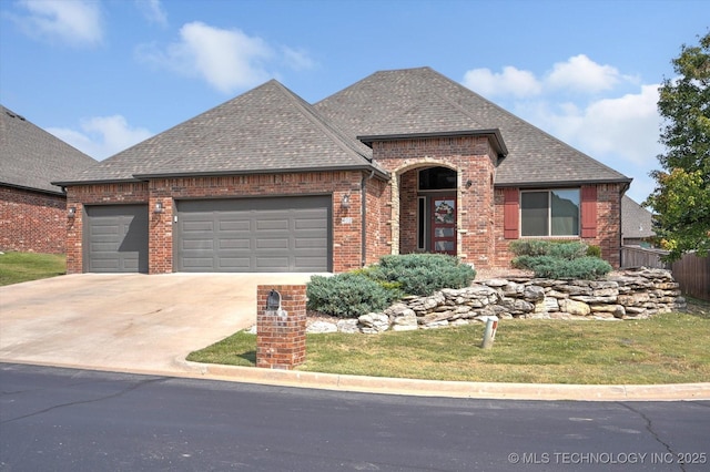 view of front of home with a garage, a shingled roof, concrete driveway, and brick siding