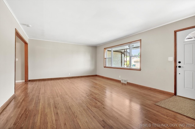 unfurnished room with ornamental molding and hardwood / wood-style floors