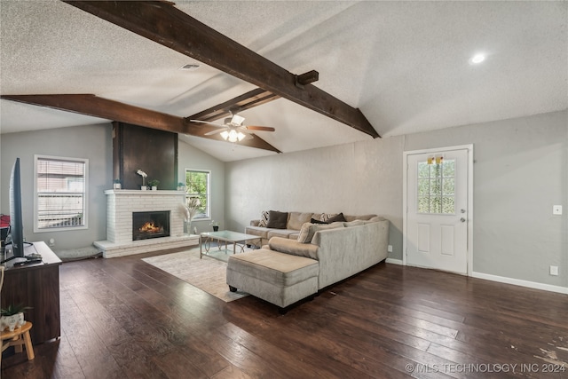 living room featuring plenty of natural light, a brick fireplace, ceiling fan, vaulted ceiling with beams, and dark wood-type flooring