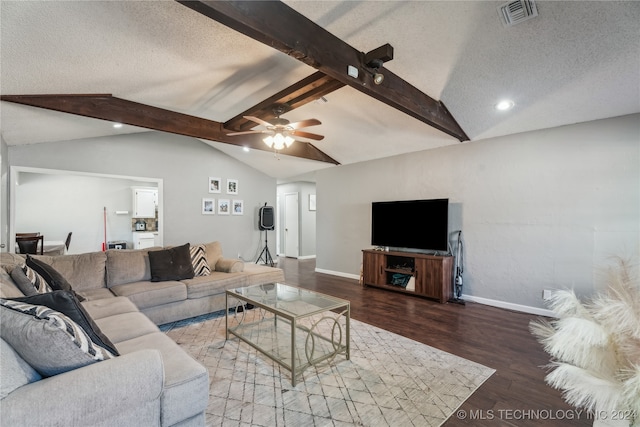 living room with a textured ceiling, ceiling fan, hardwood / wood-style flooring, and vaulted ceiling with beams