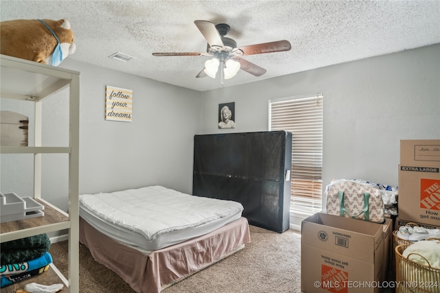 bedroom with light carpet, a textured ceiling, and ceiling fan