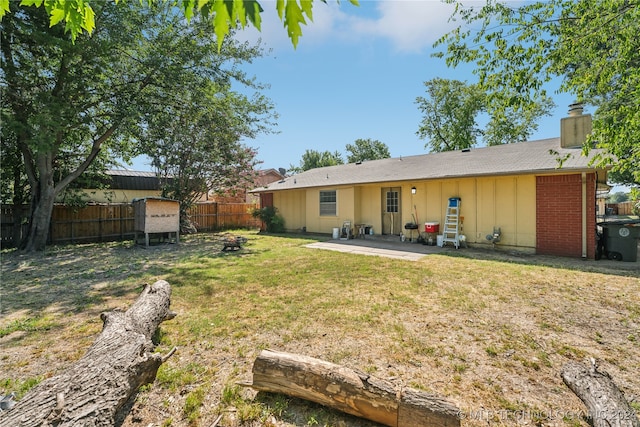 rear view of house with a lawn and a patio