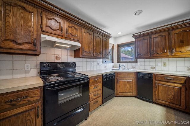 kitchen featuring black appliances, tasteful backsplash, and sink