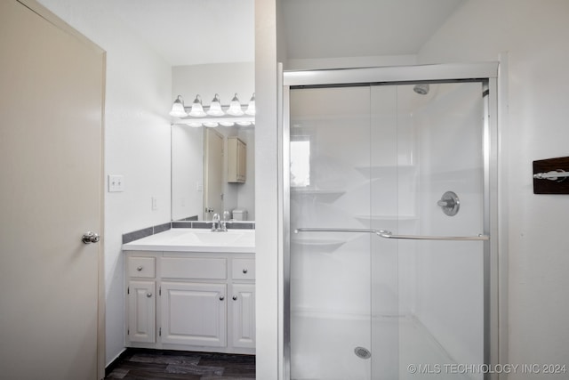 bathroom with vanity, hardwood / wood-style floors, and a shower with shower door