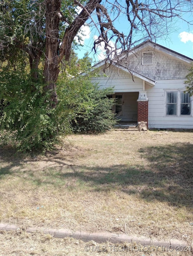 view of side of home with a yard