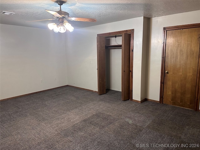 unfurnished bedroom with ceiling fan, dark colored carpet, and a textured ceiling