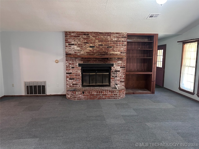 unfurnished living room with a fireplace, a textured ceiling, and carpet