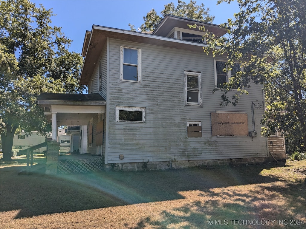 back of property featuring a lawn