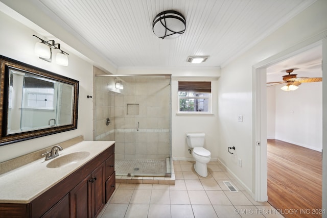 bathroom featuring toilet, crown molding, vanity, wood-type flooring, and a shower with shower door