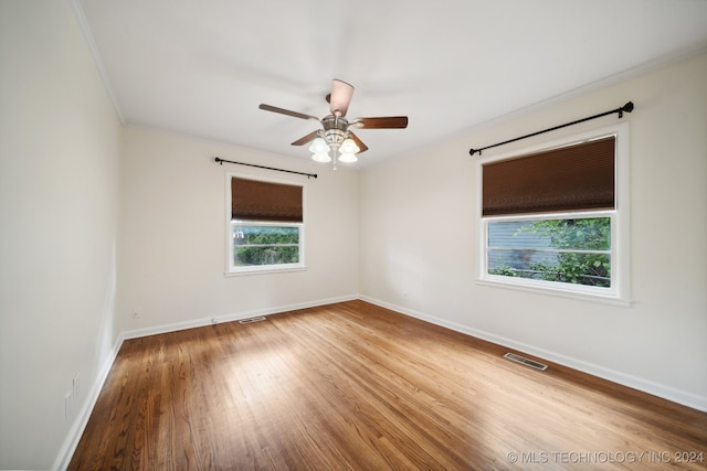 unfurnished room with crown molding, wood-type flooring, and ceiling fan