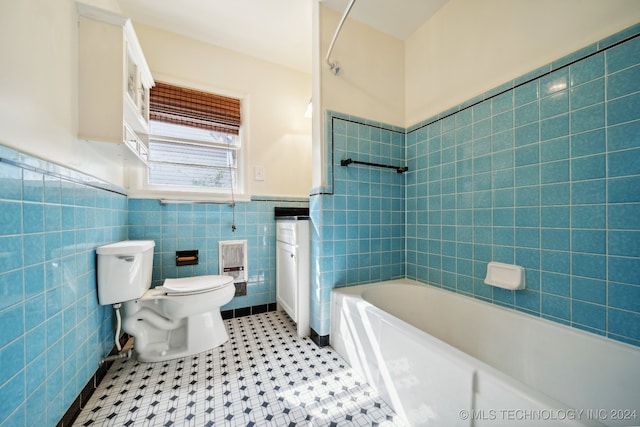 bathroom with tile walls, toilet, and tiled shower / bath combo