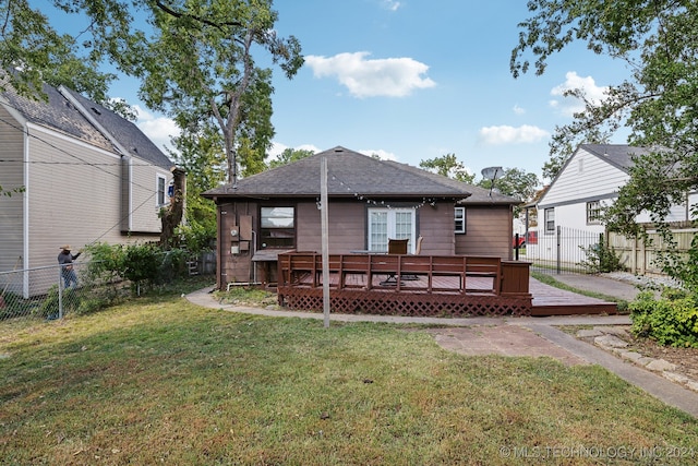 rear view of house with a wooden deck and a yard