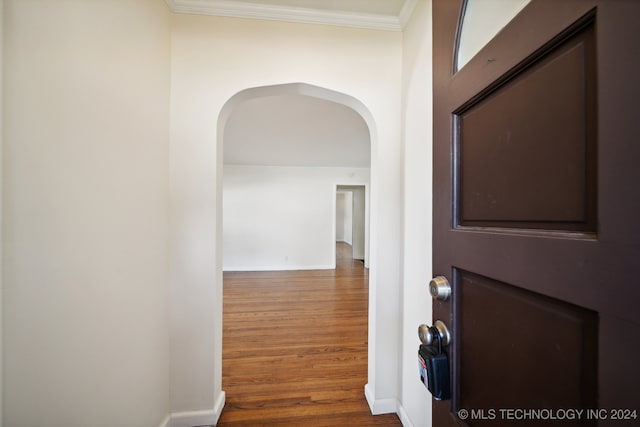 hall featuring ornamental molding and dark hardwood / wood-style flooring