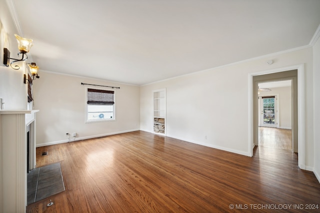 unfurnished living room featuring crown molding and dark wood-type flooring