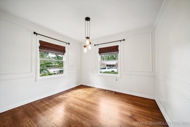 empty room with crown molding and wood-type flooring