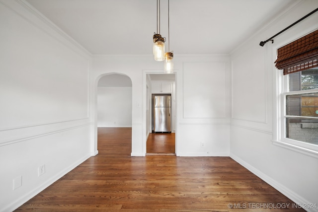 empty room with ornamental molding and dark wood-type flooring