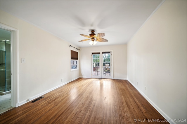 spare room with a barn door, ceiling fan, and hardwood / wood-style flooring