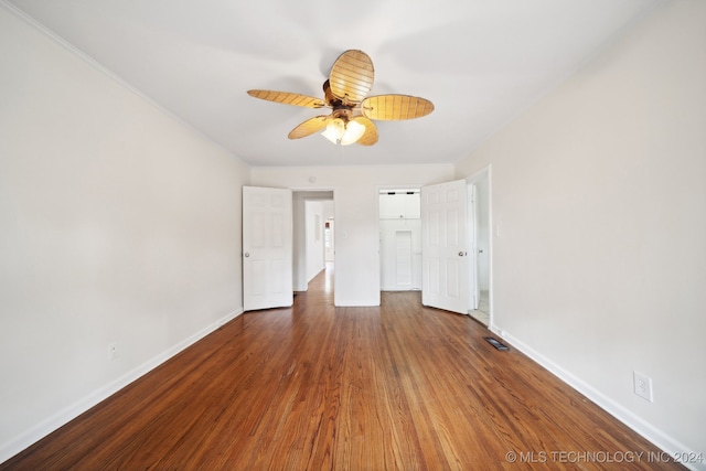 unfurnished bedroom with ceiling fan and dark hardwood / wood-style flooring