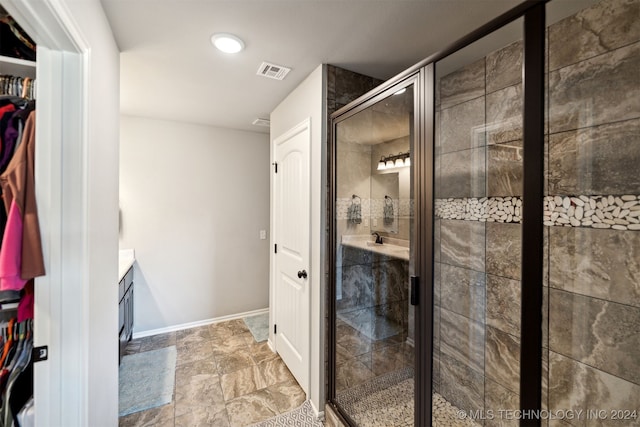 bathroom featuring vanity and a shower with shower door