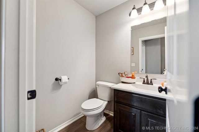 bathroom with wood-type flooring, vanity, and toilet