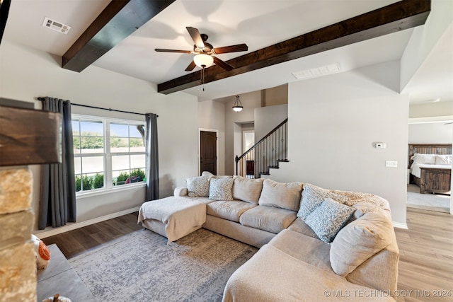 living room with light hardwood / wood-style floors, beam ceiling, and ceiling fan