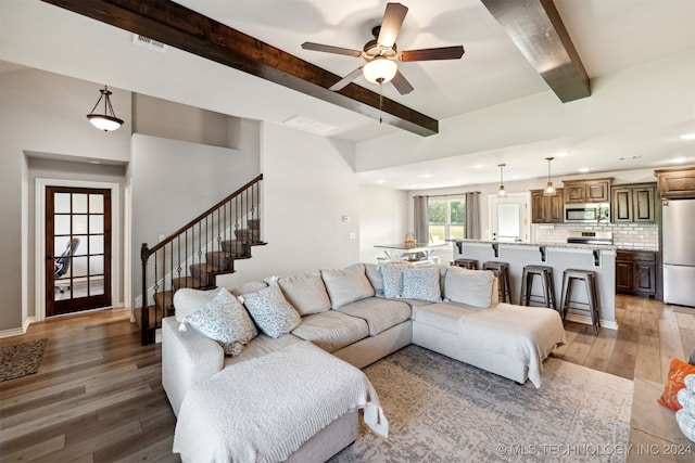 living room with beam ceiling, dark hardwood / wood-style flooring, and ceiling fan